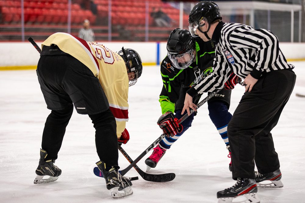 Referee dropping the puck for a faceoff